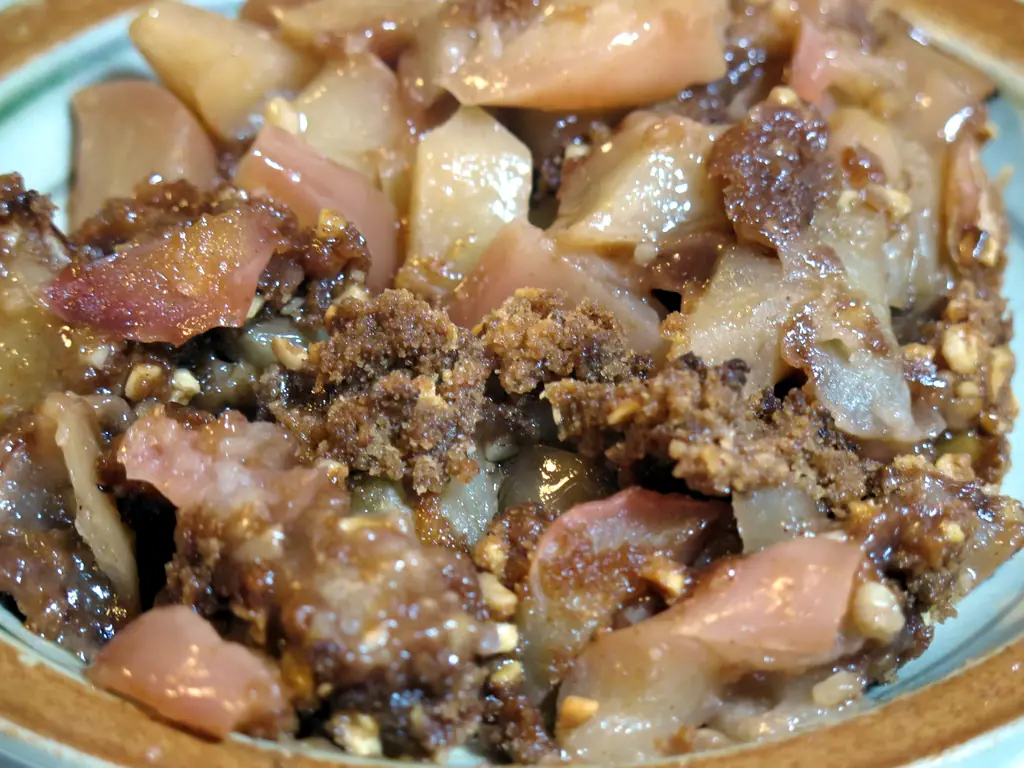 Close-up of a baked apple crisp with soft apple pieces and crumble topping