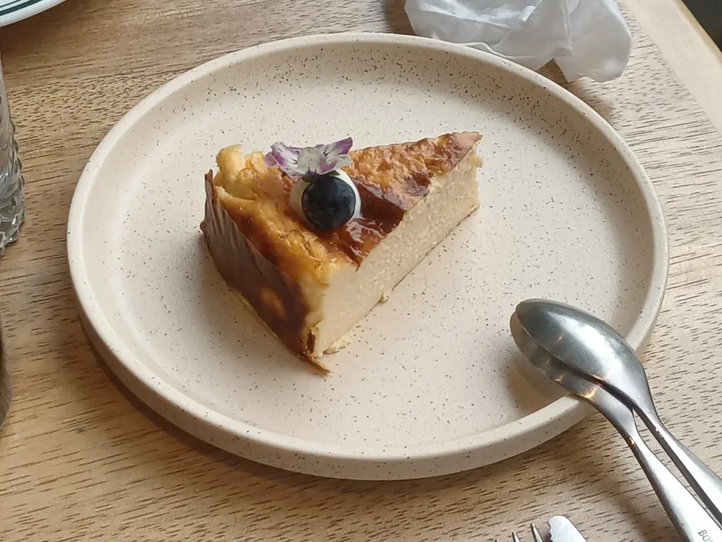 Slice of Basque-style cheesecake with blueberries on a plate