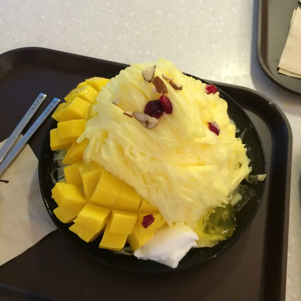 Mango bingsu: shaved ice piled with fresh mango cubes in a bowl