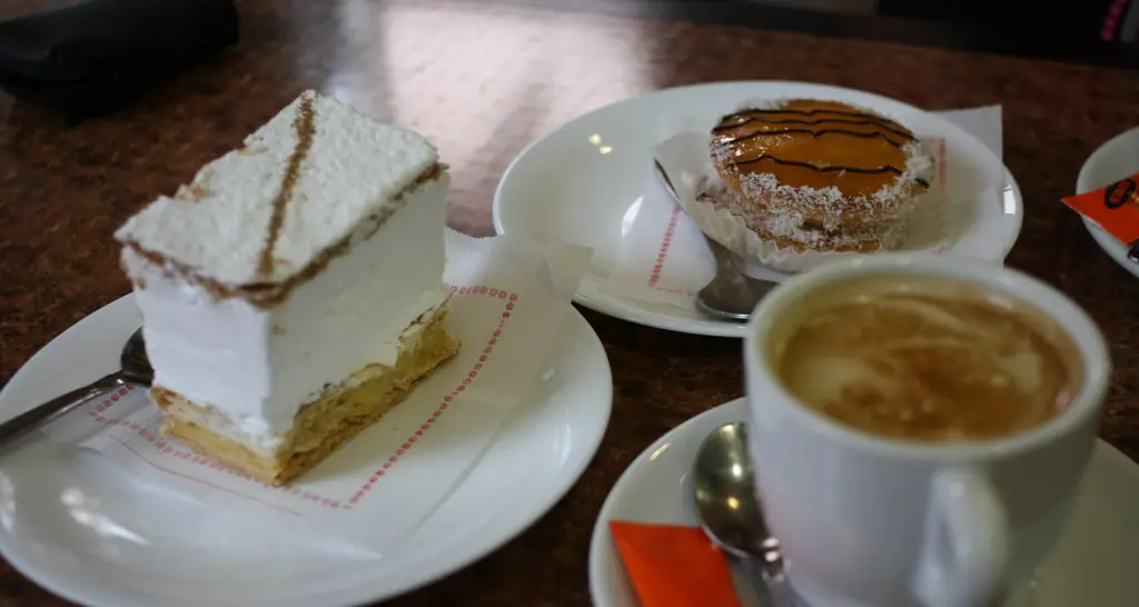 Slice of cake beside a cup of coffee on a café table