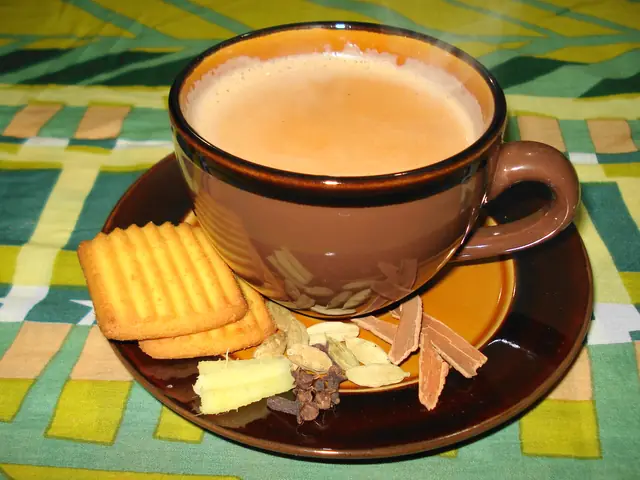 Cup of masala chai with biscuits and whole spices