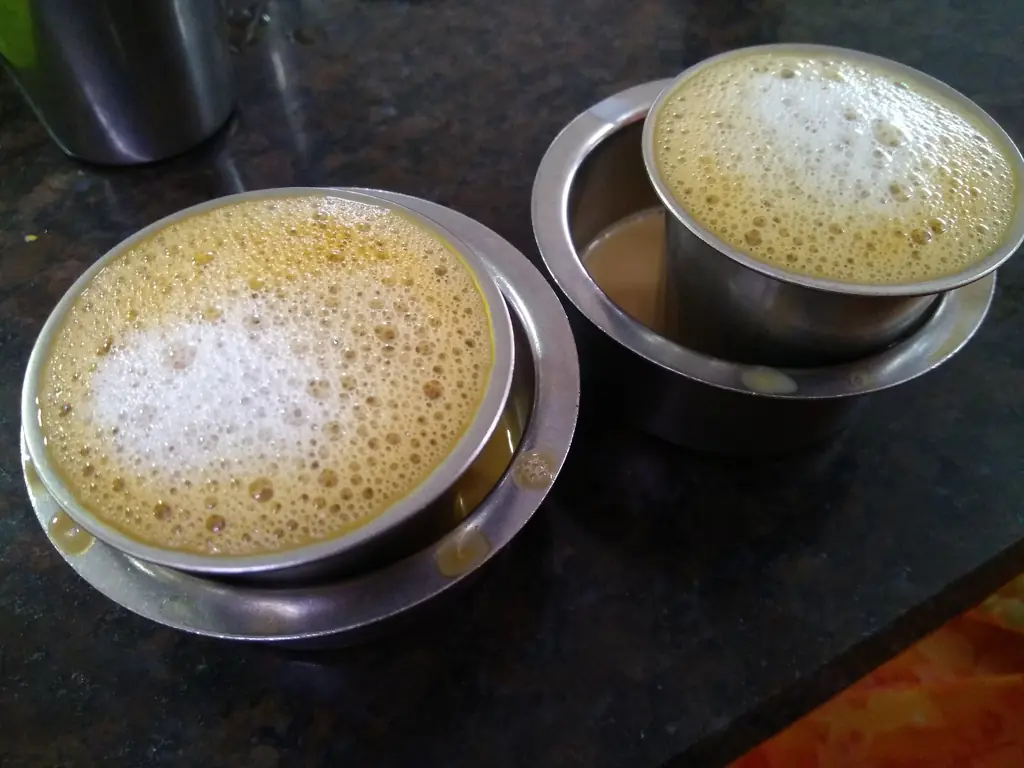 South Indian filter coffee in a steel tumbler and dabara, with a frothy top