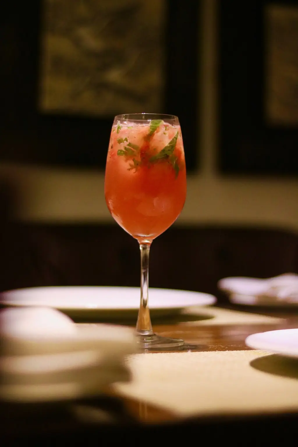 Tall glass of watermelon basil cooler with ice, a fruit café refresher