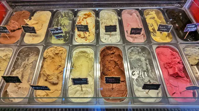 Trays of fruit and cream ice creams in a display counter