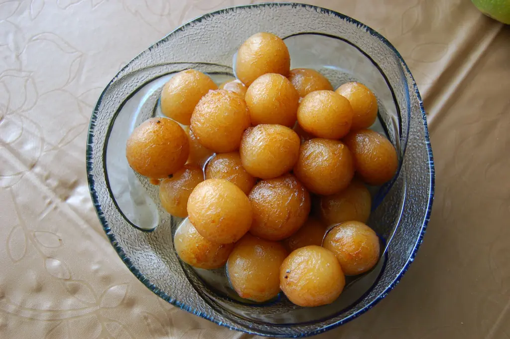 A glass bowl of golden-brown gulab jamun