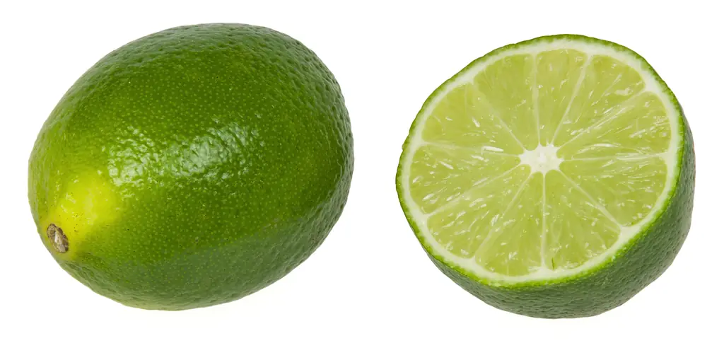A whole and a halved green lime