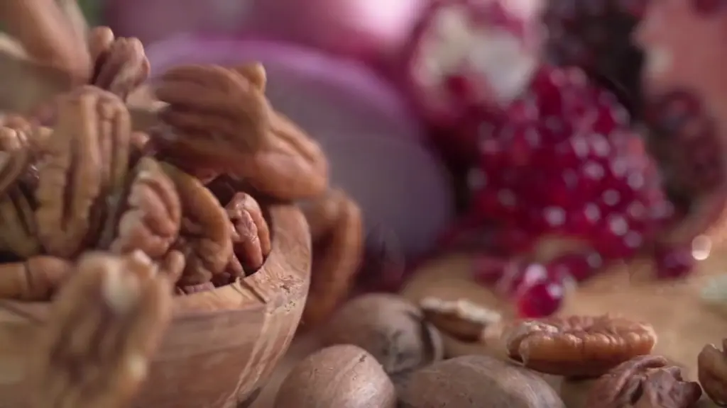 Pecans tumbling into a wooden bowl