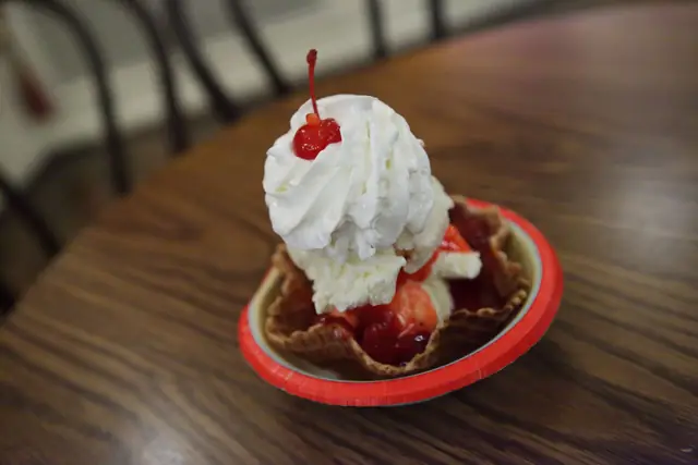 Ice cream topped with red fruit sauce