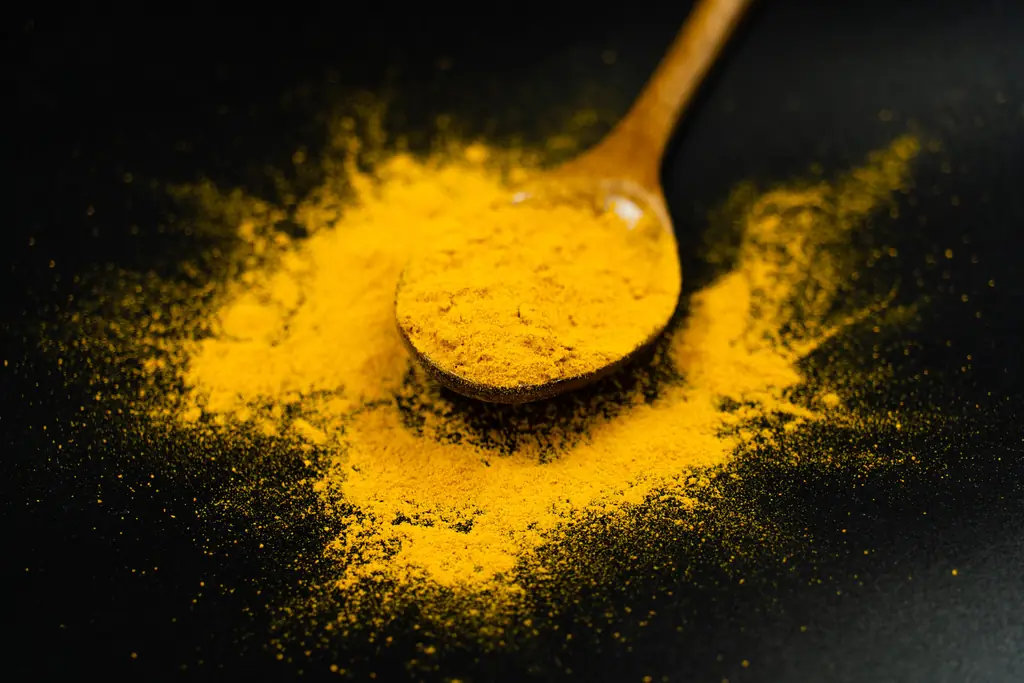 Turmeric powder with a wooden spoon